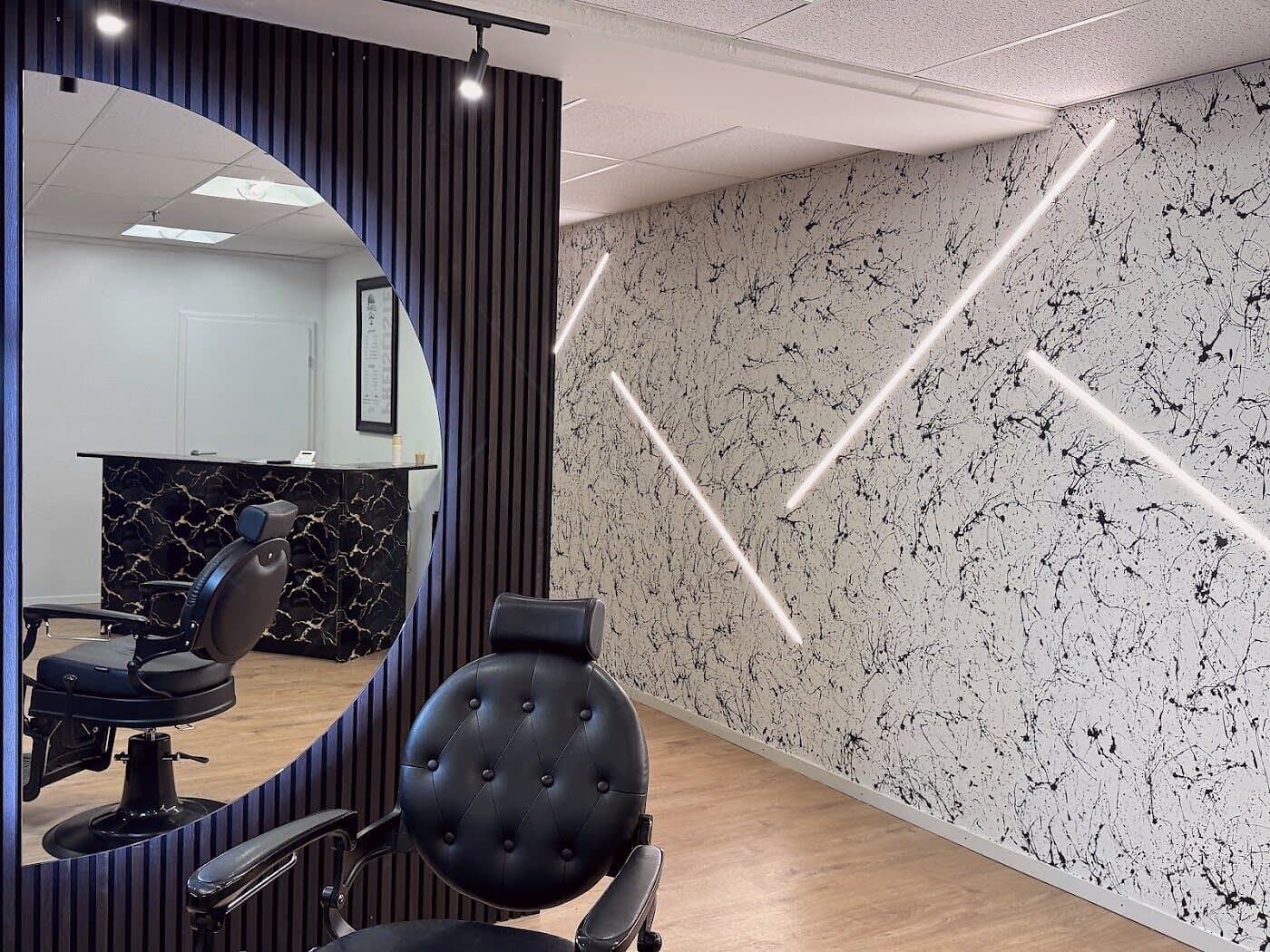 Der Salon von The Gentleman Coiffeur in Spreitenbach — schwarzer Marmor und warmes Licht